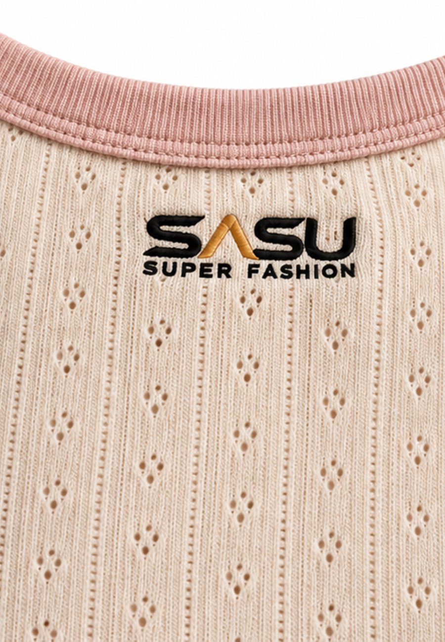 Close-up of the pointelle eyelets and pink ringer trim on a cream top